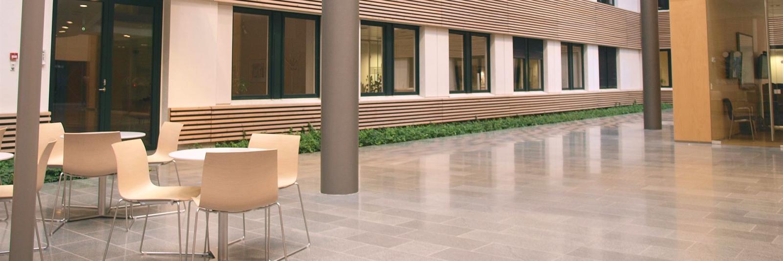 Gebäudeausgangsperformance – Facility Management Ansicht eines offenen unbesetzen Speisesaals eines Unternehmens mit runden Tischen