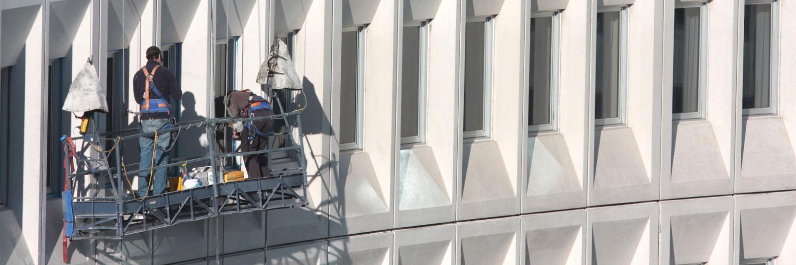Instandhaltung & Betrieb im Bereich Facility Management Reinigungsteam taetig bei der Fensterreinigung einer Gewerbeimmobilie