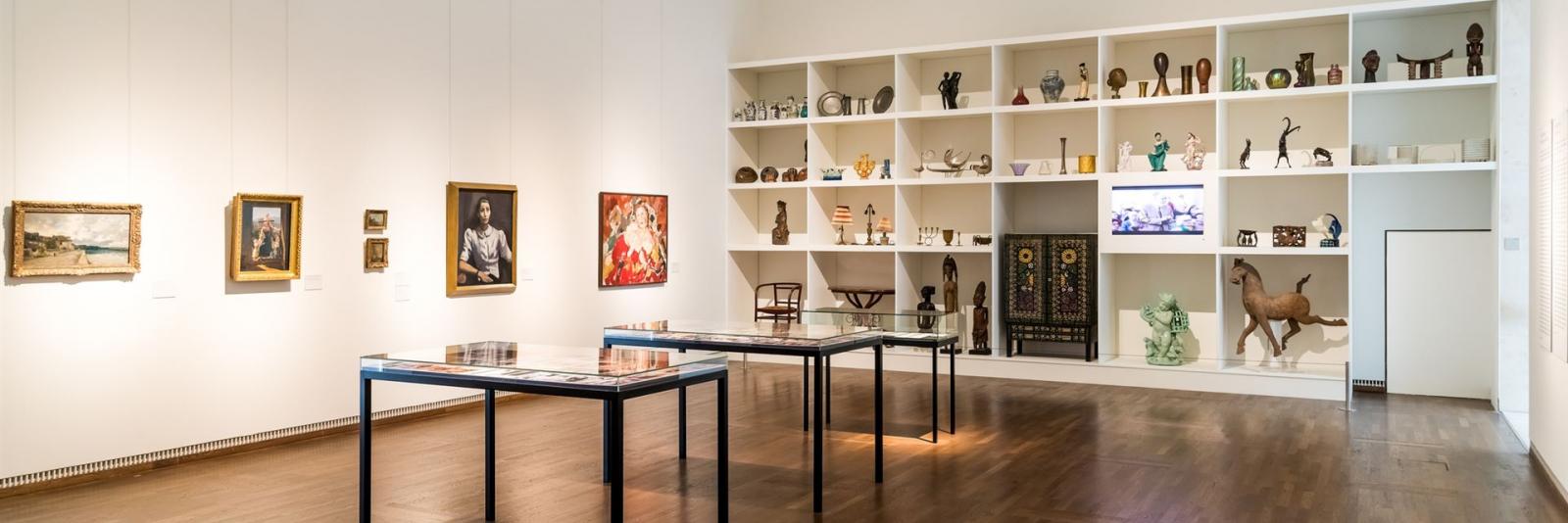 Kunstwerke & Dekorationen im Facility Management Innenansicht eines Raums mit zahlreichen Kunstwerken an einer Wand & in einem weissen Wandschrank im Leopold Museum, Wien