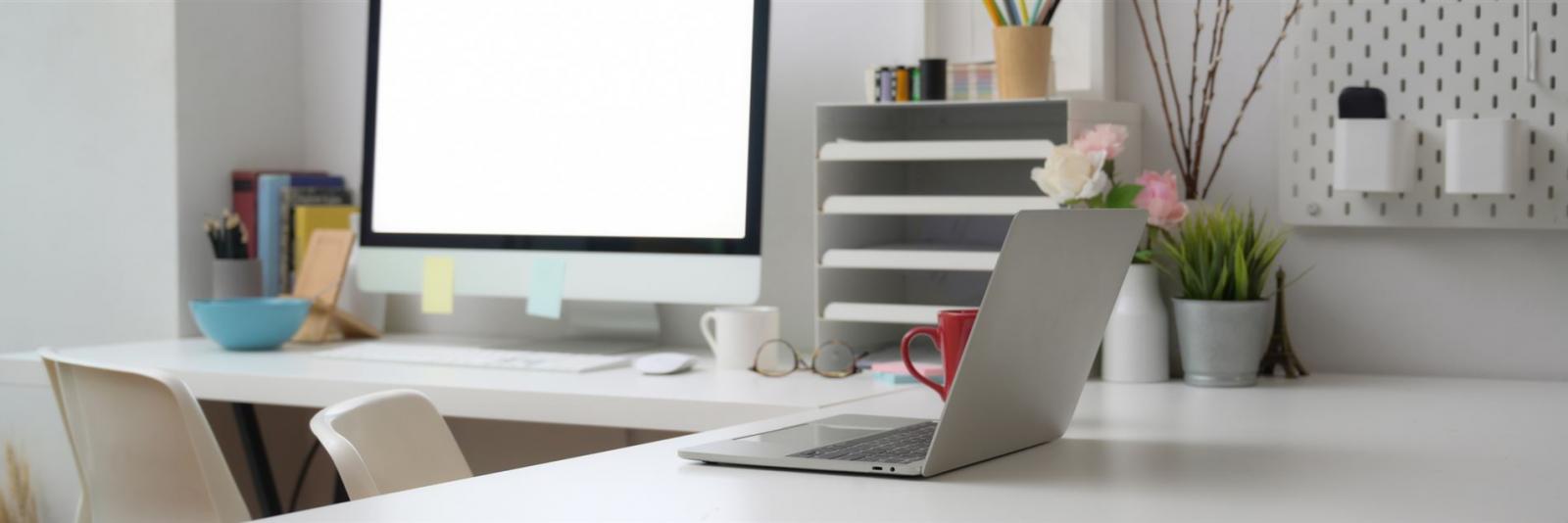 Büromaterial am Arbeitsplatz bei einer FM-Organisation Gemuetliches L-Foermiges Workstation mit ueblichem Buerobedarf und technischer Ausstattung