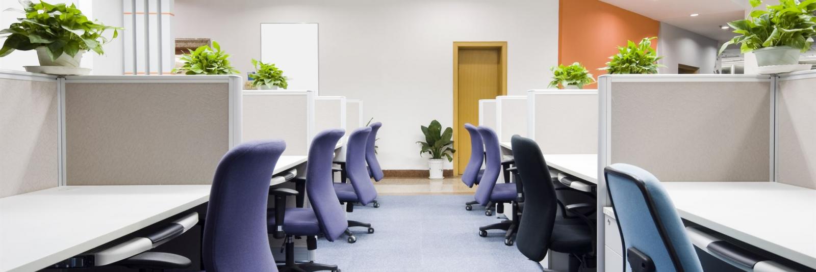 Hospitality am Arbeitsplatz im Bereich Facility Management Innenansicht eines Bueroraumes mit Arbeitstischen und Buerostuehlen reihenweise angeordnet
