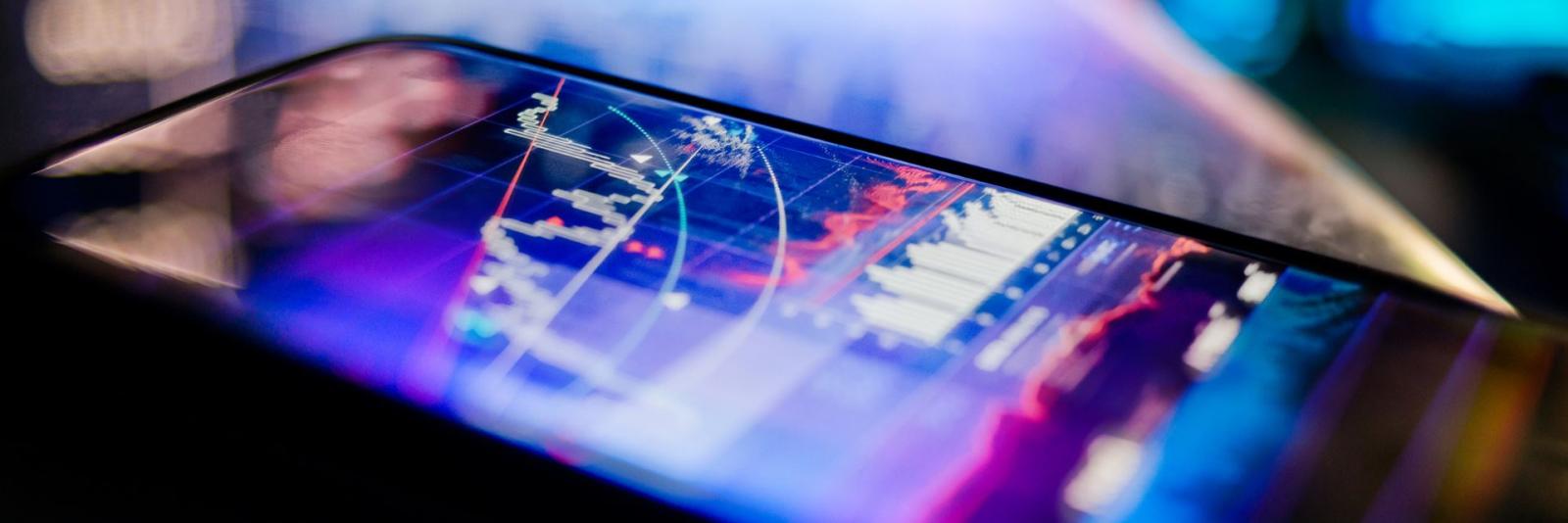 Geschäfts-IT im Bereich Facility Management Ein mobiles Geraet zeigt verschiedene Abbildungen & Grafiken von Geschaeftsdaten an